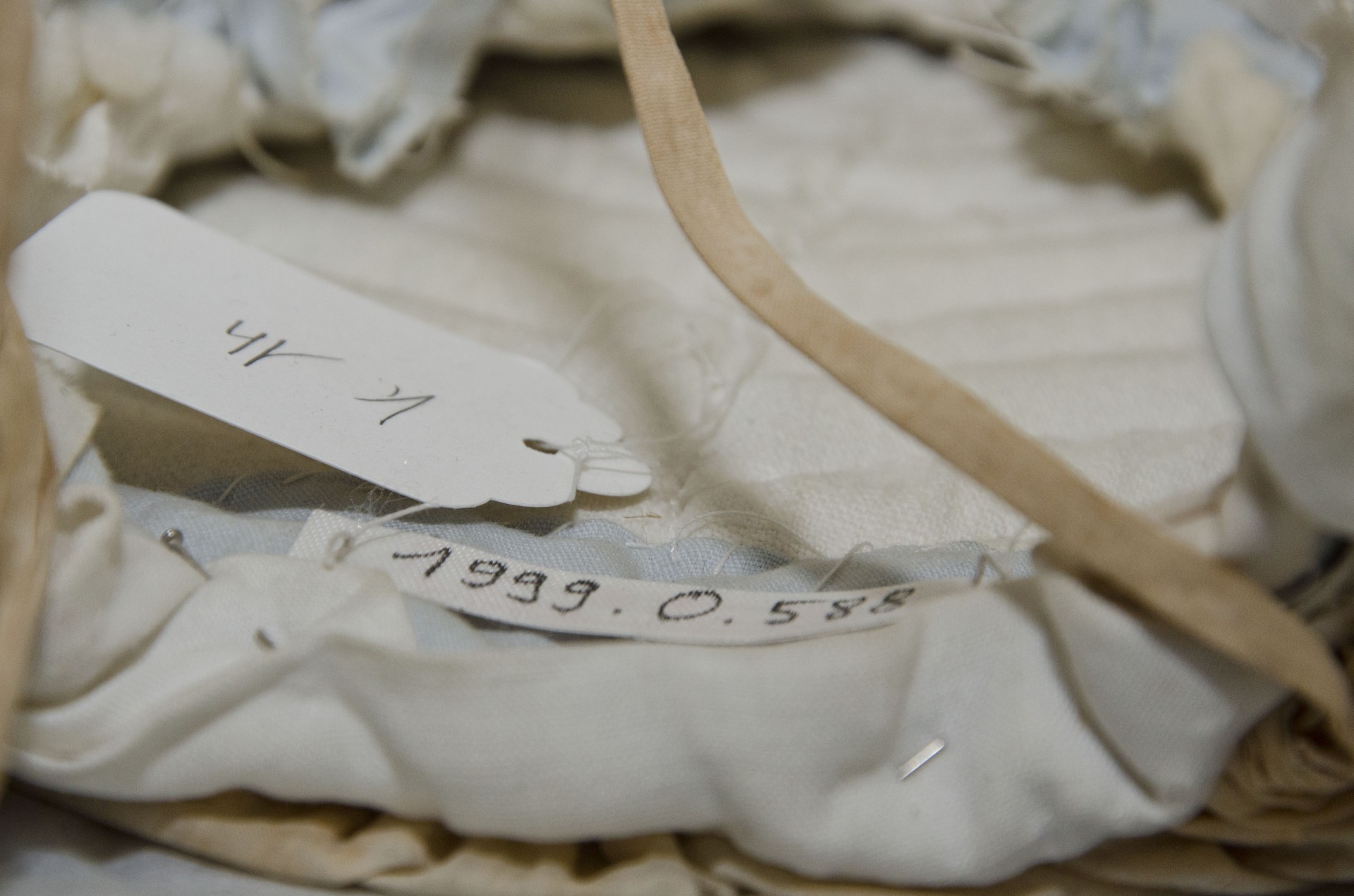 Un tag RFID fixé sur un galon cousu à une coiffe. Le numéro d'inventaire traditionnel est inscrit sur le tag.